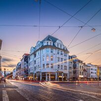 Es dämmert und viele Autos fahren über eine große Kreuzung.