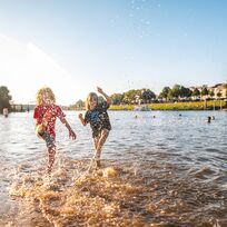 Kinder spielen am Strand.