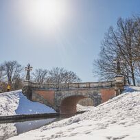 Eine Brücke die über einen kleinen Bach im Bürgerpark führt. Es liegt Schnee.