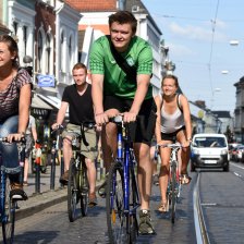 Vier junge Menschen fahren auf Fahrrädern durch eine belebte Straße; Quelle: WFB/Ingo Wagner