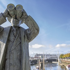 A statue of a man holding binoculars.