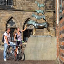 Zwei Fahrradfahrer und die Statue der Bremer Stadtmusikanten
