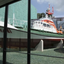 Blick durch ein großes Fenster des Focke Museums auf ein an Land liegendes Schiff der Seenotrettung