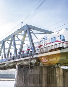 Zug in Bremen, der über eine Brücke fährt. Die Brücke ist über der Weser. 