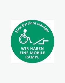 Ein runder grüner Aufkleber mit Aufdruck: Grafik eines Menschen im Rollstuhl vor einer Rampe. Schriftzug "Eine Barriere weniger - Wir haben eine mobile Rampe".