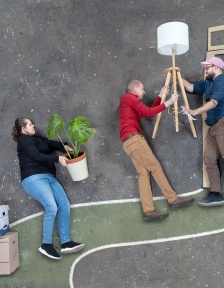 Eine Collage zeigt drei Personen, die mit einem Umzug beschäftigt sind. Sie tragen Einrichtungsgegenstände in eine Wohnung. 