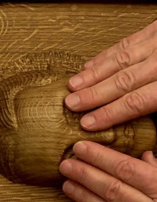 Hände ertasten das Porträt von Katharina von Bora aus Eichenholz.