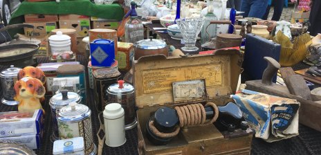 Ein altes Telefon und altes Porzellangeschirr auf einem Verkaufstisch auf dem Flohmarkt auf der Bürgerweide