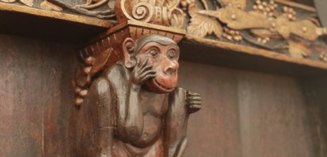 Ein hölzerner Affe ist Teil einer Fassade.