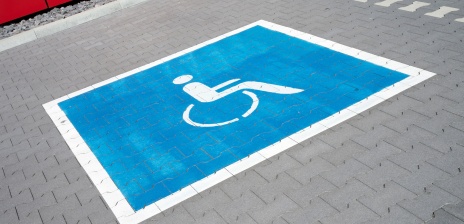 Ein aufgemaltes Rollstuhl-Symbol auf einem Behindertenparkplatz.