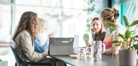 Vier Frauen sitzen gemeinsam an einem Tisch und erarbeiten ein Thema zusammen