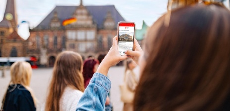 Blick durch ein Smartphonebildschirm auf den Marktplatz, der Marktplatz ist verschwommen 