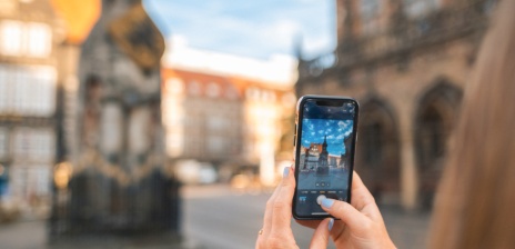 Eine Frau macht mit ihrem Smartphone ein Foto vom Roland