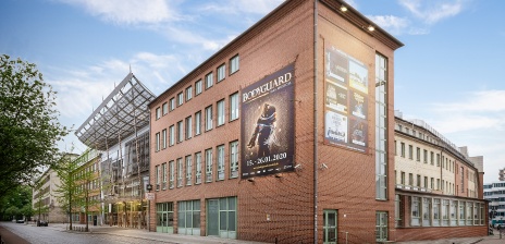 Außenansicht des Metropol Theaters Bremen mit Backsteinfassade und Musicalplakat von Bodyguard.