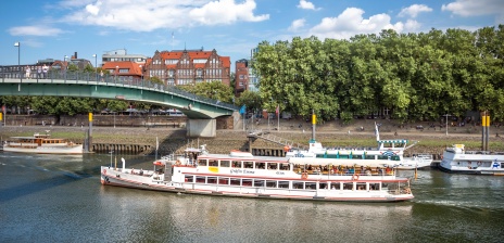 Ein Schiff fährt in der Weser bei einer Brücke. 