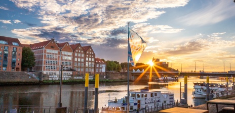 Ein Schiff liegt an der Schlachte, die Sonne geht langsam unter.