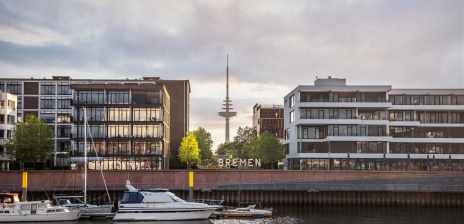 In front of the Bremen Sign are boats in the jetty. 