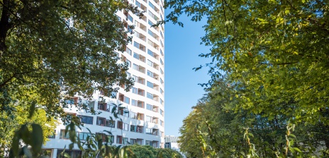 Ein Hochhaus steht in einer Parkanlage.