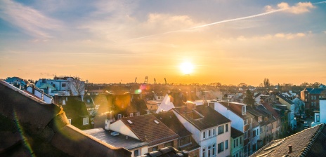 Die Sonne geht über den Dächern der Stadt unter. Im Hintergrund ist das Weserstadion zu sehen.