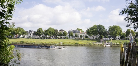 Auf der Weser fährt ein Schiff vorbei. Im Hintergrund ist der Osterdeich. 