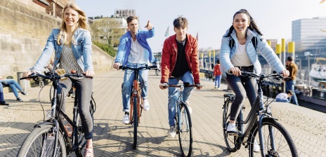 Vier junge Menschen fahren Fahrrad an der Weserpromenade
