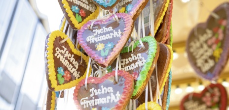 Bunte Lebkuchenherzen hängen an einem Süßigkeiten-Stand. 