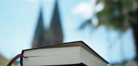 Im Vordergrund ein Buch im Hintergrund der Dom.