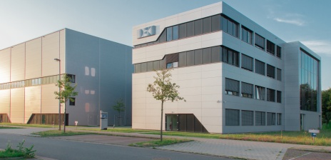 Ein hellgraues Gebäude mit der blauen Aufschrift DFKI