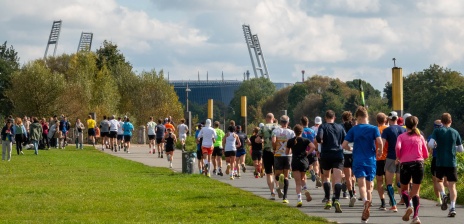 Eine Gruppe mit Läufer*innen rennt auf das Weserstadion zu