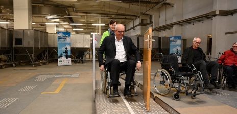 Im Rollstuhl über eine Rampe durch eine Tür - für Bürgermeister Bovenschulte im Rollstuhl- und Blindenparcours eine neue Erfahrung. 