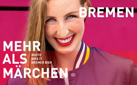 Eine lachende Frau vor einem pinken Hintergrund. Sie hat rot-blonde Haare, Sommersprossen und trägt roten Lippenstift. Schriftzug im Bild: "Bremen - Mehr als Märchen. Boote, Bike it, Bremer Bier". 