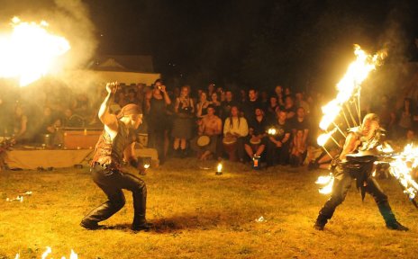 Zwei Männer bieten abends eine Feuershow.