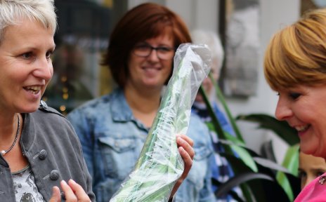 Zwei Frauen halten einen Dekoartikel in den Händen und unterhalten sich auf dem Hökermarkt darüber