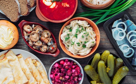 Table on which many Russian dishes can be seen.