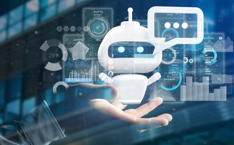 Eine Hand hält einen kleinen Roboter in die Höhe. Dieser blickt direkt in Kamera und hat eine Sprechblase an seinem Kopf. Im Hintergrund sind verschiedene Statistiken und Apps zu sehen. 