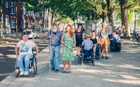 Eine Menschengruppe an der Schlachte. Einige von ihnen sind blind oder sitzen im Rollstuhl.