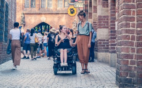 Zwei Frauen in der Böttcherstraße. Eine von ihnen sitzt im Rollstuhl.