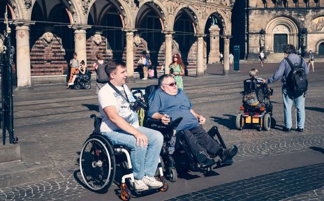 Menschen mit und ohne Beeinträchtigungen vor dem Bremer Rathaus auf dem Marktplatz.