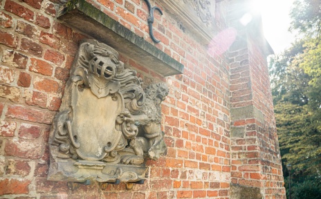 Ornament eines Fabeltiers an der Mauer der Burg Blomendal.
