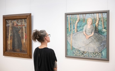 Eine Frau betrachtet ein Gemälde der Künstlerin Paula Modersohn-Becker. 
