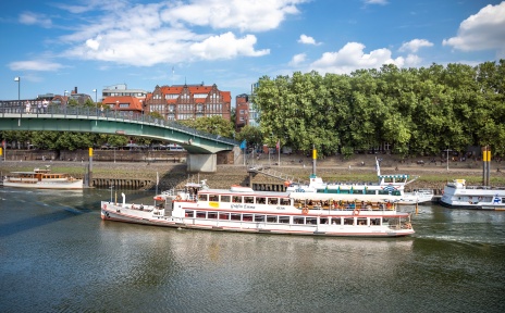 Ein Schiff fährt in der Weser bei einer Brücke. 