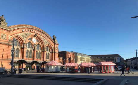 Vor dem Hauptgebäude des Bremer Hauptbahnhofes stehen rote Losbuden.