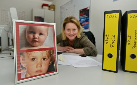 Eine Frau am Schreibtisch mit Kinderfotos.