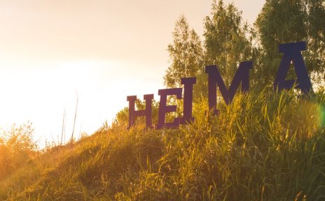 Große Buchstaben stehen auf einer Wiese und bilden das Wort "Heimat"