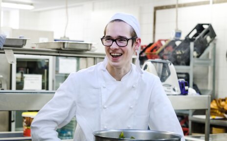 Ein lachender junger Koch (Quelle: Andi Weiland | www.gesellschaftsbilder.de)
