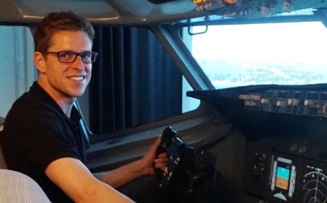 Christian Siegmund lächelt im Flugsimulator in die Kamera.