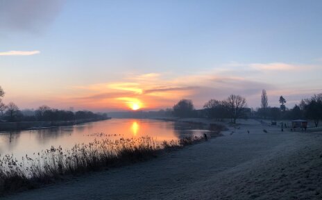 Über dem Werdersee geht gerade die Sonne auf. Die Wiesen sind gefroren. 