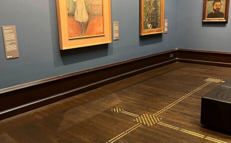 Ein Ausstellungsraum der Kunsthalle Bremen. Auf dem Boden ist ein Bodenleitsystem. An der Wand hängen Gemälde.