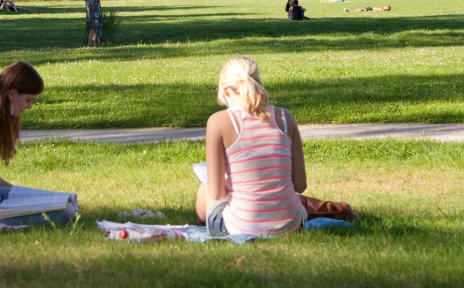 Zwei Frauen sitzen im Gras und lesen 