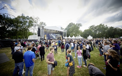 Menschen stehen vor einer Open-Air-Bühne